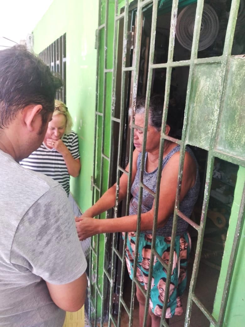 A woman behind bars shaking hands with a man.