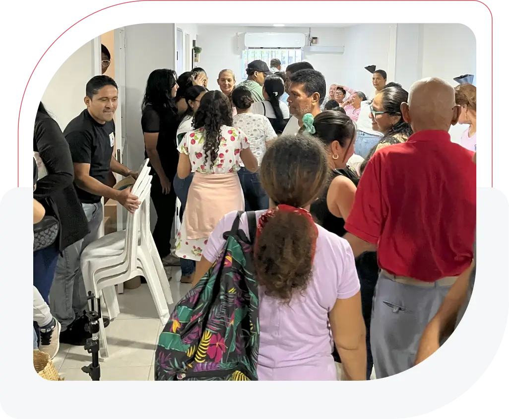 People gathered in a crowded indoor space, interacting and waiting.